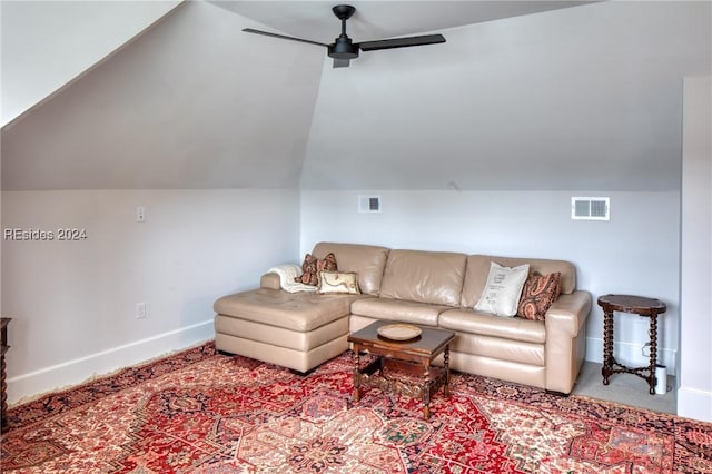 carpeted living room with ceiling fan and vaulted ceiling