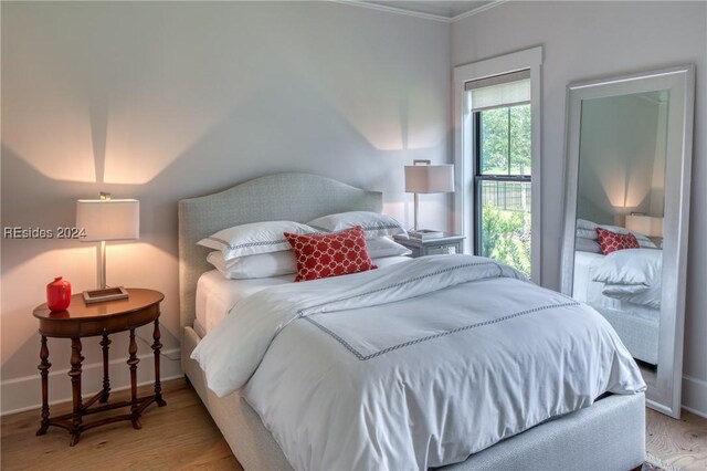 bedroom with ornamental molding and hardwood / wood-style floors