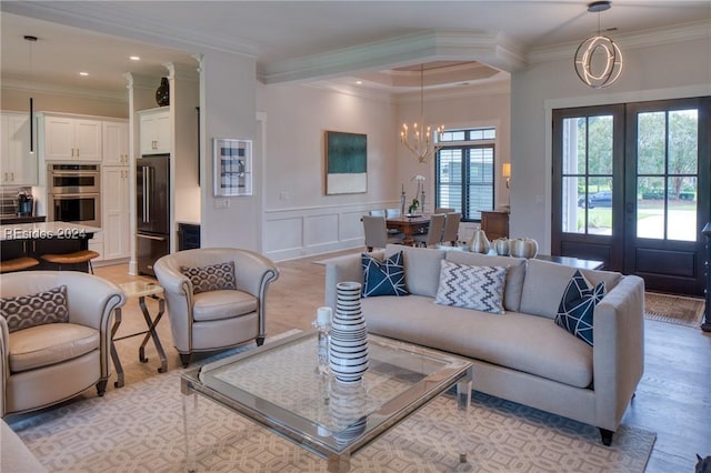 living room featuring crown molding, french doors, and a chandelier