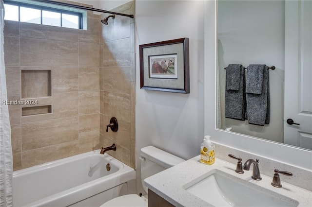 full bathroom with vanity, tiled shower / bath, and toilet