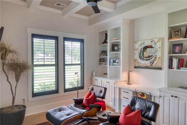 sitting room featuring coffered ceiling, built in features, ceiling fan, beam ceiling, and light hardwood / wood-style floors