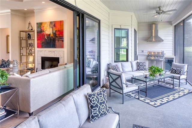 living room featuring ceiling fan, ornamental molding, a fireplace, and wood walls