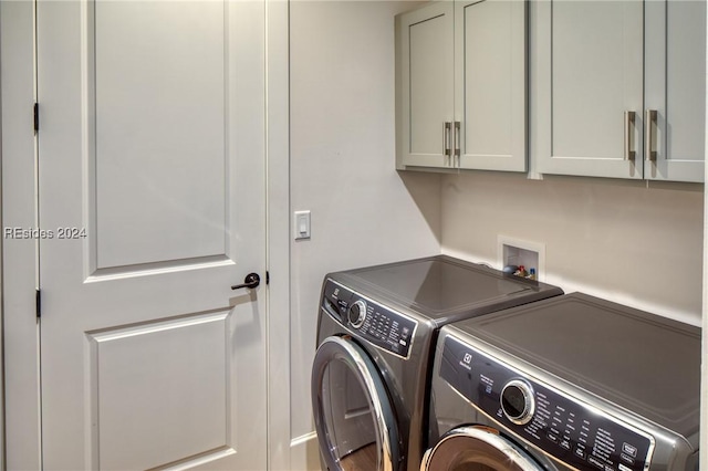 laundry area with washer and clothes dryer and cabinets