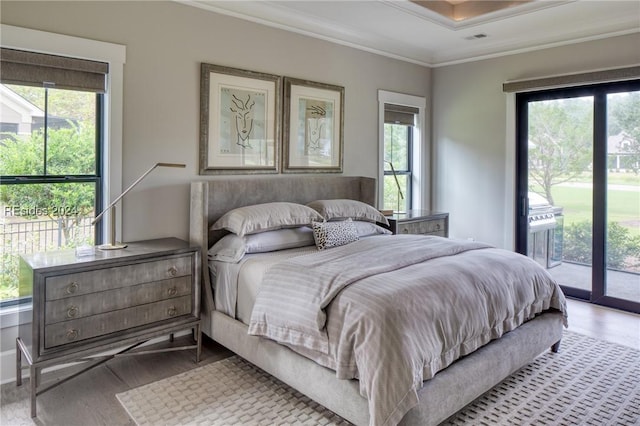 bedroom featuring multiple windows, access to exterior, light hardwood / wood-style flooring, and ornamental molding