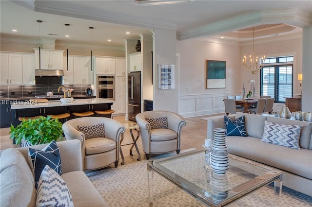 living room with ornamental molding and a chandelier