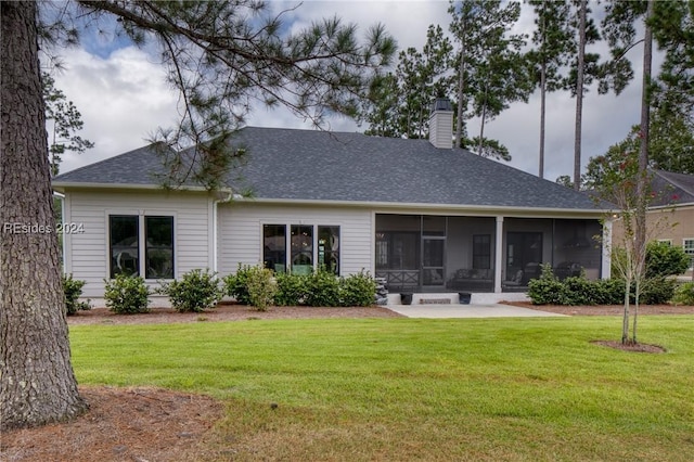 back of property featuring a sunroom and a lawn