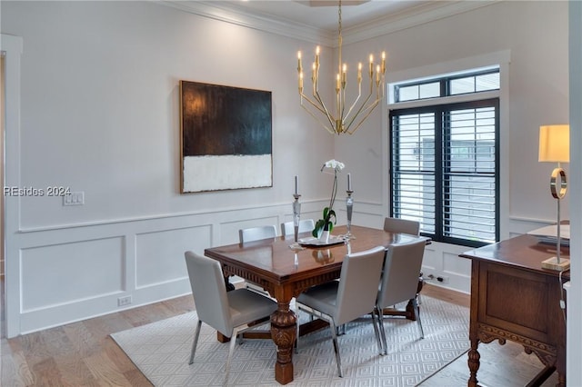 dining space featuring crown molding, an inviting chandelier, and light wood-type flooring