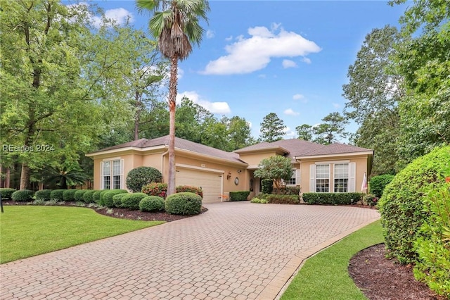 view of front of home with a garage and a front lawn