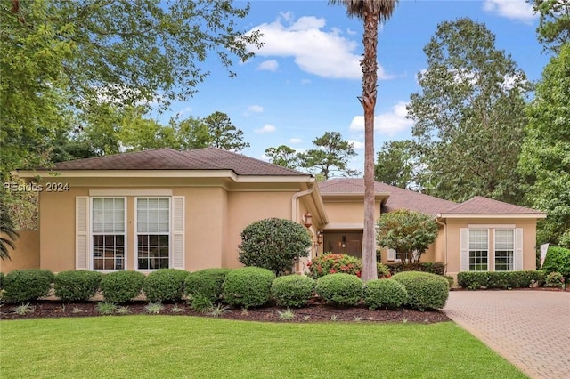 mediterranean / spanish home with a front lawn