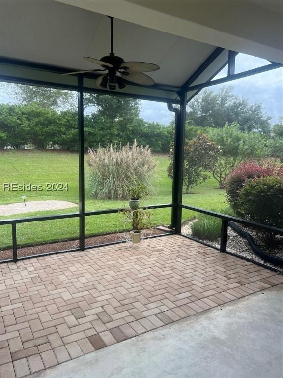 unfurnished sunroom with ceiling fan