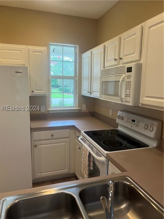 kitchen with white cabinets and white appliances