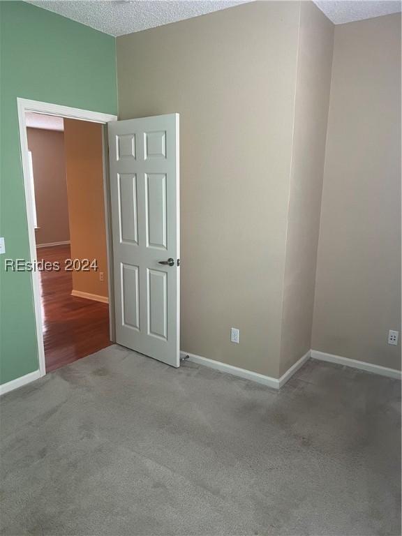 carpeted spare room with a textured ceiling