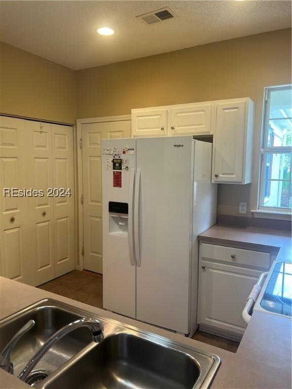 kitchen with white cabinetry, white appliances, and sink