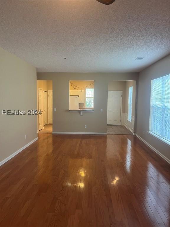 unfurnished room with dark hardwood / wood-style floors and a textured ceiling