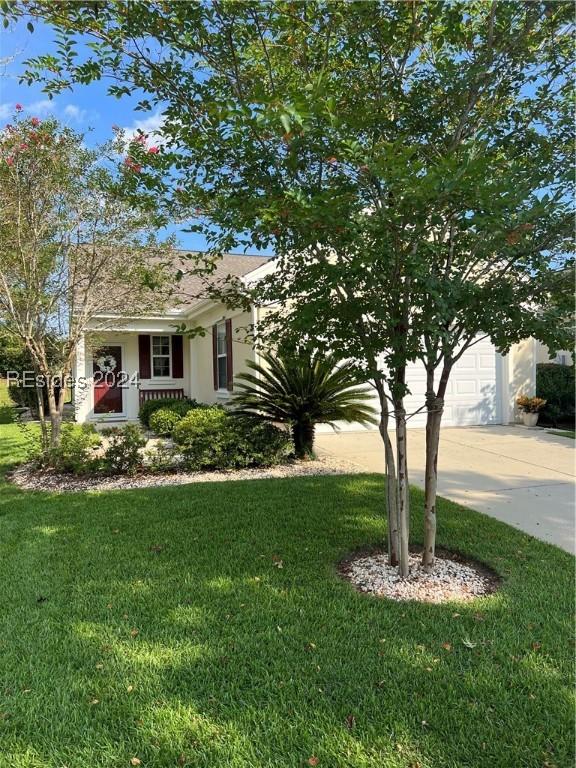 view of front of property with a garage, a porch, and a front yard