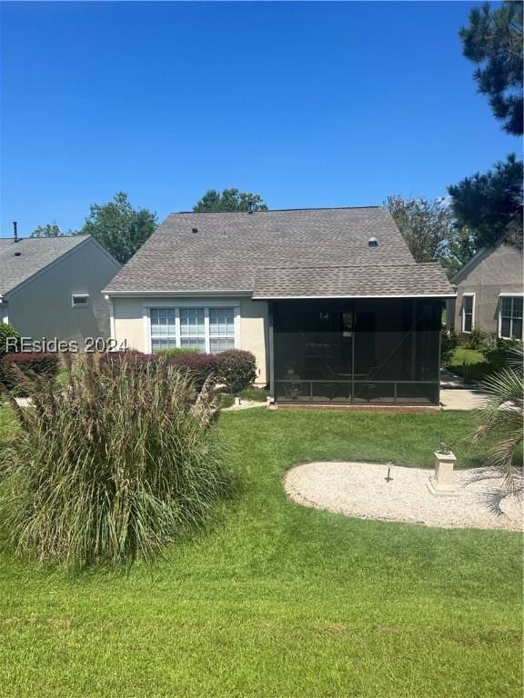 rear view of house with a sunroom and a lawn