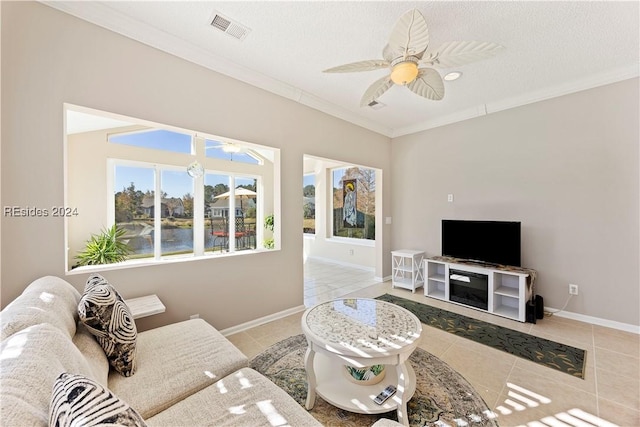 living room featuring light tile patterned flooring, ceiling fan, crown molding, and a textured ceiling