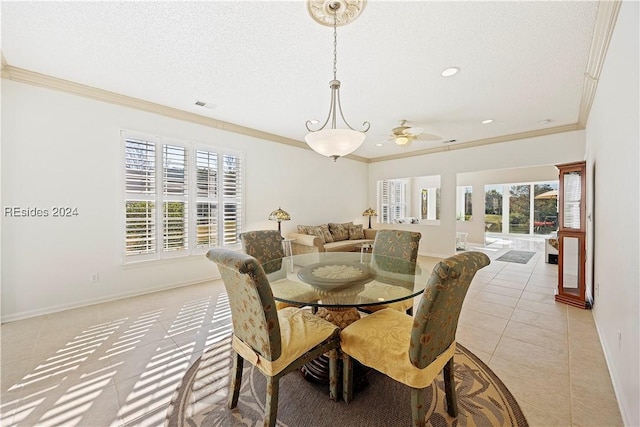 dining room with ornamental molding, a textured ceiling, and light tile patterned floors