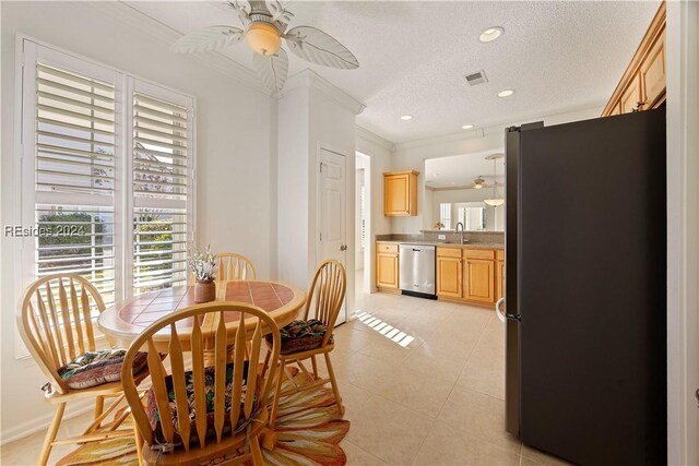 dining area featuring light tile patterned floors, ornamental molding, a textured ceiling, and ceiling fan