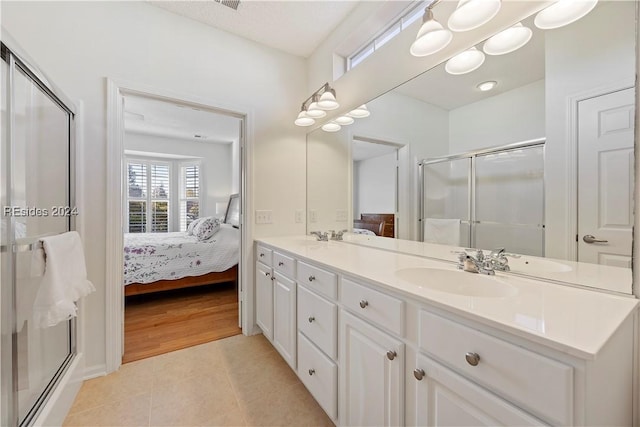 bathroom featuring tile patterned floors, an enclosed shower, and vanity