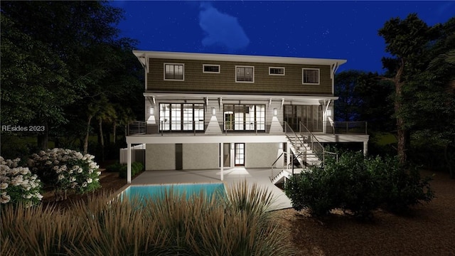 back house at night featuring a patio