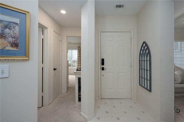 foyer featuring light colored carpet