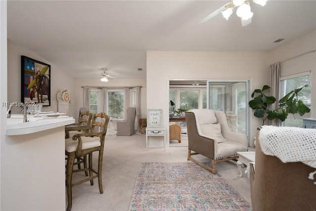 living room featuring light colored carpet and ceiling fan