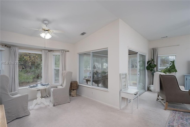 living area with lofted ceiling, light colored carpet, and ceiling fan