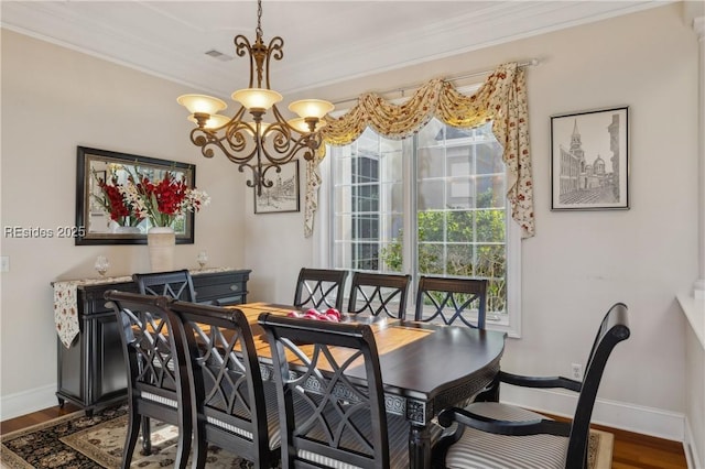 dining area featuring crown molding, dark hardwood / wood-style flooring, and a chandelier