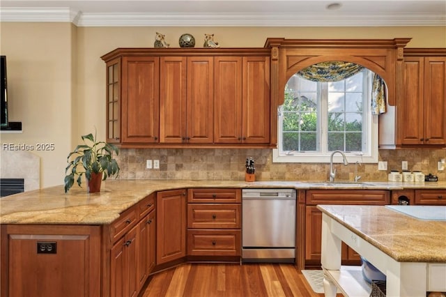 kitchen featuring sink, tasteful backsplash, light stone counters, light wood-type flooring, and stainless steel dishwasher