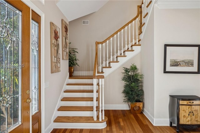 foyer entrance with lofted ceiling and hardwood / wood-style floors