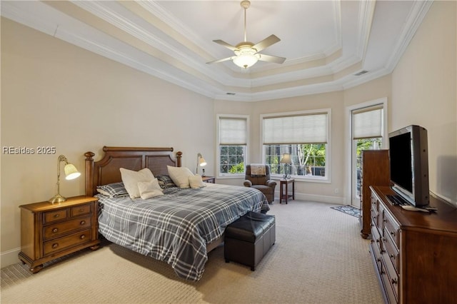 bedroom with crown molding, a tray ceiling, light colored carpet, and ceiling fan