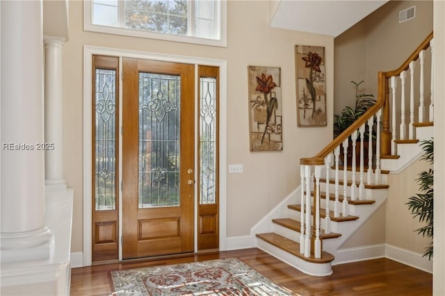 foyer entrance with hardwood / wood-style flooring and ornate columns