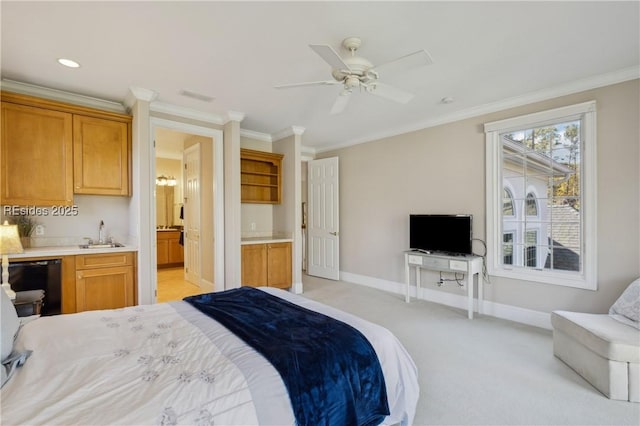 carpeted bedroom with sink, ensuite bath, ornamental molding, and ceiling fan