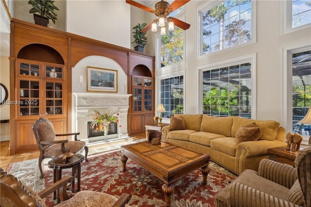 living room with ceiling fan and a high ceiling