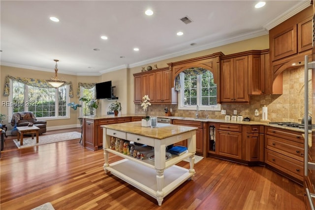 kitchen with decorative light fixtures, dark hardwood / wood-style flooring, sink, and a kitchen island