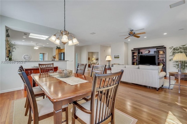 dining room featuring ceiling fan with notable chandelier and light wood-type flooring