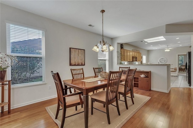 dining area featuring plenty of natural light, ceiling fan with notable chandelier, and light hardwood / wood-style flooring