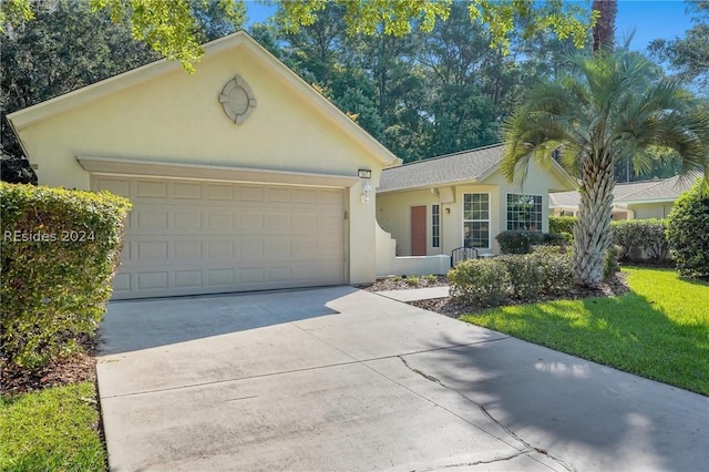 ranch-style house featuring a garage and a front yard