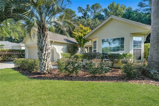 view of property exterior featuring a garage and a lawn