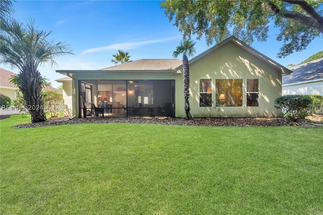 back of property with a sunroom and a yard