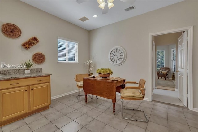 tiled dining space with ceiling fan