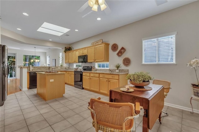 kitchen with kitchen peninsula, light tile patterned floors, light brown cabinets, and black appliances