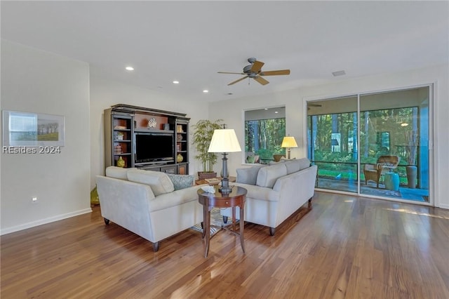 living room featuring dark wood-type flooring and ceiling fan