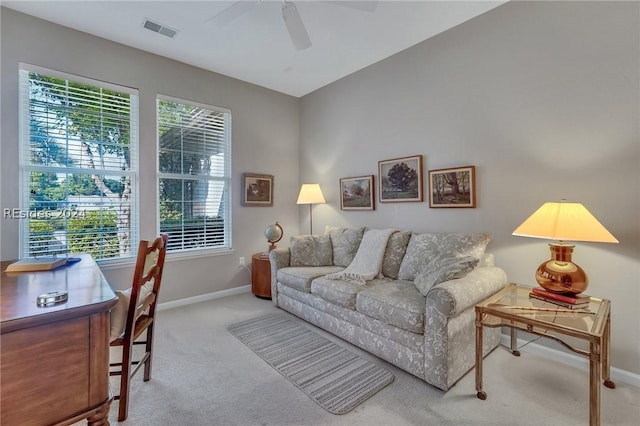 living room with ceiling fan, plenty of natural light, and light carpet