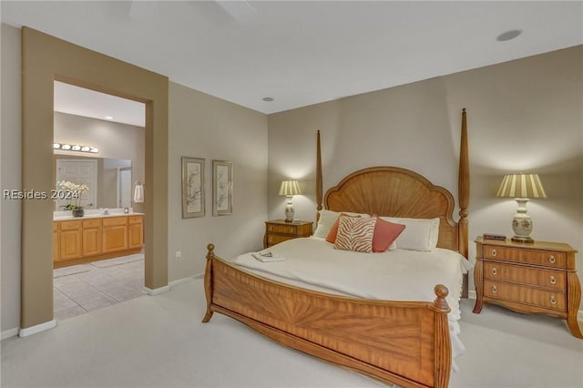 bedroom with connected bathroom and light colored carpet