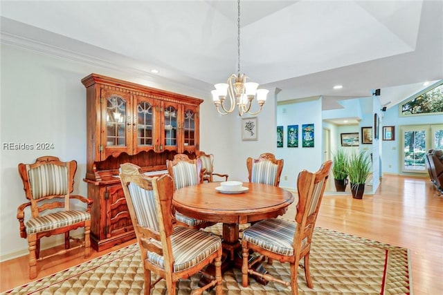 dining room with ornamental molding, a chandelier, and light hardwood / wood-style floors