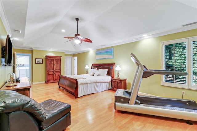 bedroom with light hardwood / wood-style floors, ornamental molding, a raised ceiling, and ceiling fan