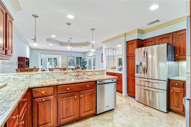 kitchen featuring sink, stainless steel appliances, light stone counters, decorative light fixtures, and a raised ceiling