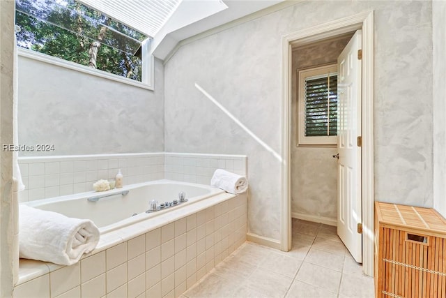 bathroom with a relaxing tiled tub and tile patterned floors